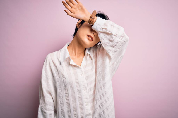 Young beautiful asian girl wearing casual shirt standing over isolated pink background covering eyes with arm, looking serious and sad. Sightless, hiding and rejection concept - Foto, Imagem