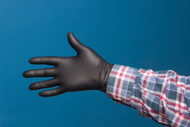 Hygiënische handbescherming, fijne zwarte handschoen om aanraking in de handen te voorkomen. Hand- en vingertekens. - Foto, afbeelding