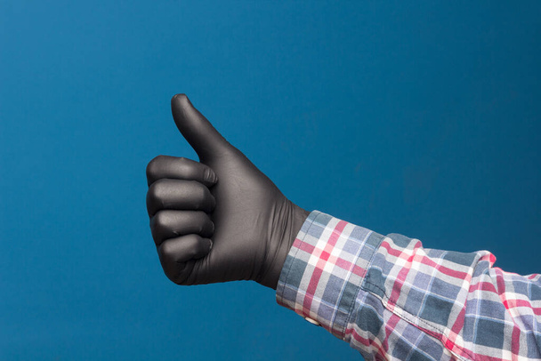 Higieniczna ochrona dłoni, drobna czarna rękawica, aby uniknąć utraty kontaktu z dłońmi. Znaki dłoni i palców. - Zdjęcie, obraz