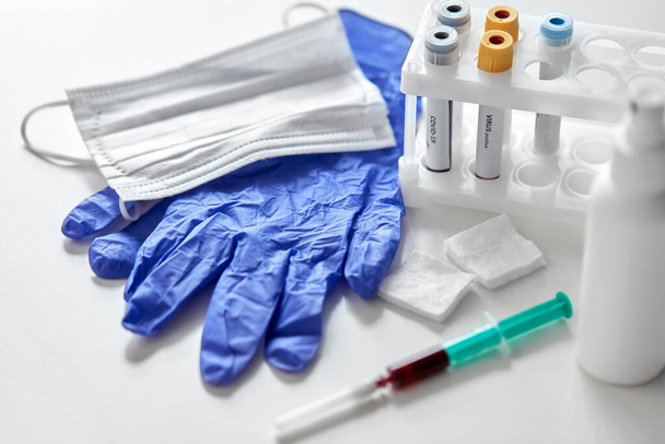 beakers with coronavirus blood tests and syringe - Photo, image