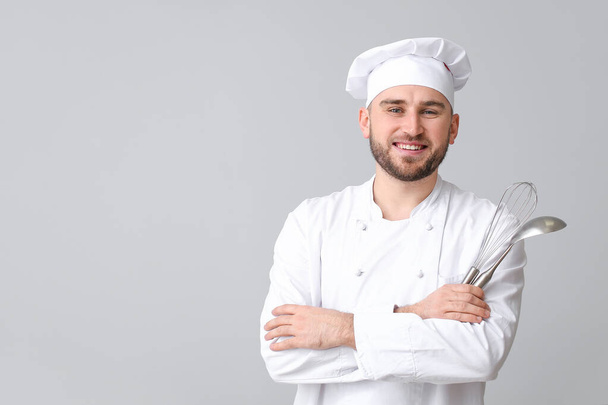 Knappe mannelijke chef-kok op lichte achtergrond - Foto, afbeelding