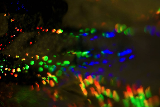 Fond abstrait foncé avec débordement, multicolore, bokeh arc-en-ciel et reflets
. - Photo, image