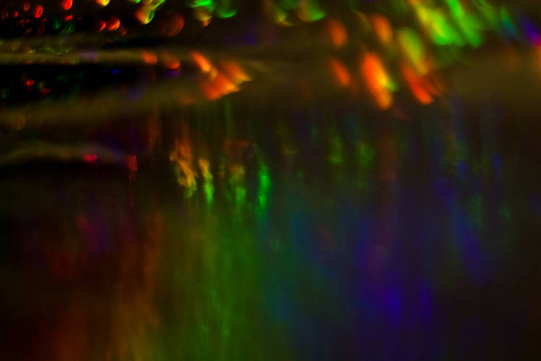 Fond abstrait foncé avec débordement, multicolore, bokeh arc-en-ciel et reflets
. - Photo, image