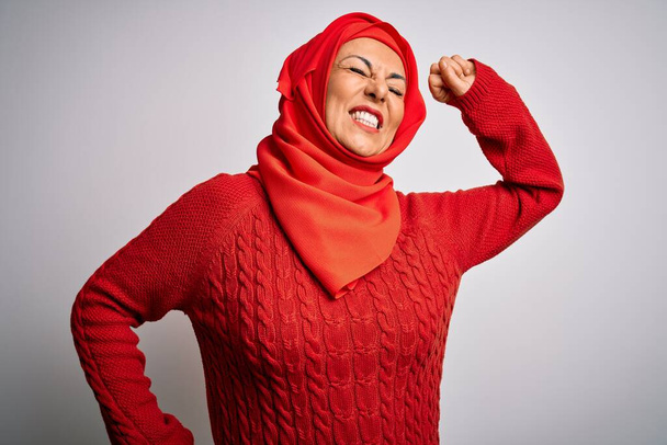 Mulher morena de meia idade vestindo muçulmano tradicional hijab sobre fundo branco isolado que se estende para trás, cansado e relaxado, sonolento e bocejo para o início da manhã
 - Foto, Imagem