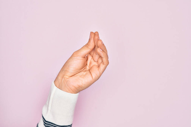 Χέρι του Καυκάσου νεαρός άνδρας δείχνει τα δάχτυλα πάνω από απομονωμένο ροζ φόντο κάνει ιταλική χειρονομία με τα δάχτυλα μαζί, κίνηση χειρονομία επικοινωνίας - Φωτογραφία, εικόνα