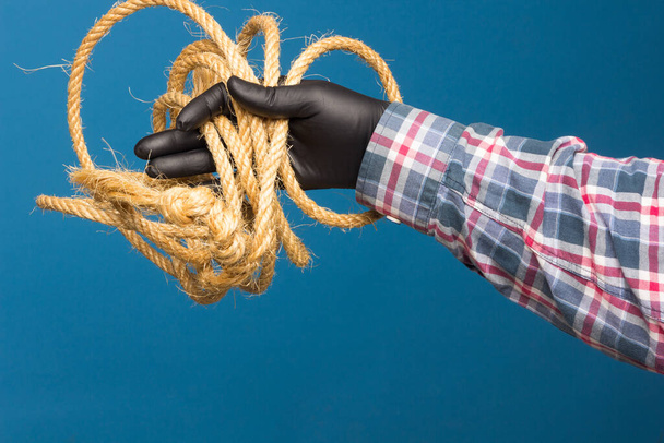 Žluté lano v odborné ruce dospělého s ochranou. Silné lano k vázání objektů. - Fotografie, Obrázek