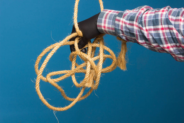 Žluté lano v odborné ruce dospělého s ochranou. Silné lano k vázání objektů. - Fotografie, Obrázek