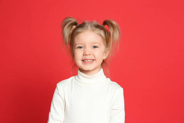 Portrait of cute little girl on red background - Φωτογραφία, εικόνα