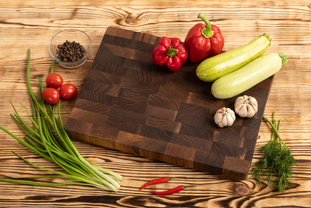 Fresh vegetables and greens on wooden cutting board - Valokuva, kuva