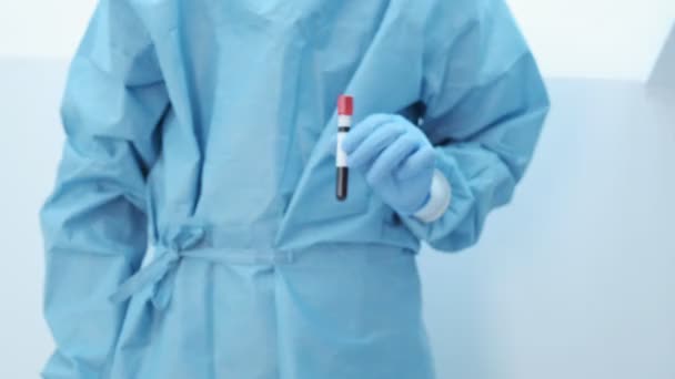 mikrobiológus, orvosi dolgozó kéz kék kesztyűvel, vérvizsgálati eredményekkel - Felvétel, videó