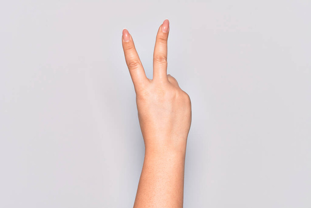 Kafkasyalı genç kadının eli iki parmağını gösteriyor, zafer işareti ve kazanan sembol. - Fotoğraf, Görsel