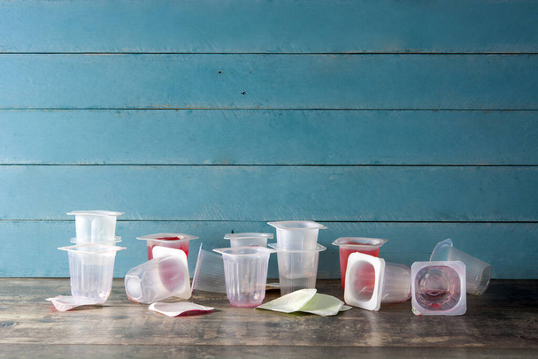 Vasos de plástico vacíos de gelatinas sobre fondo de madera. Copiar espacio
 - Foto, imagen