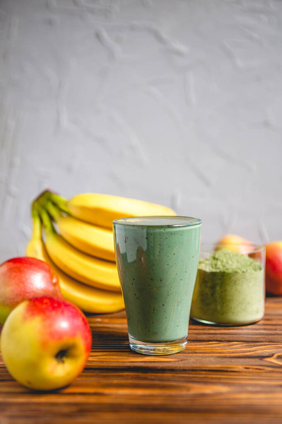 Smoothie with fresh red apple, banana and spirulina powder. Summer vitamin refreshing drink. Healthy detox diet - Фото, изображение