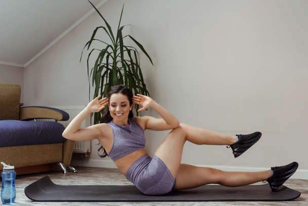 fille sportive heureuse faisant abdos et formation sur tapis de fitness à la maison pendant l'isolement personnel
 - Photo, image