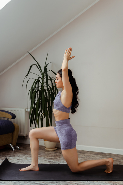 mujer joven practicando en la esterilla de yoga en casa durante el autoaislamiento
 - Foto, Imagen