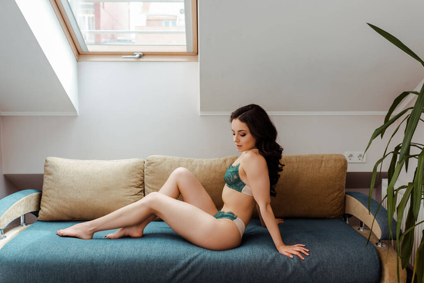 seductive beautiful girl in lingerie sitting on sofa - Fotó, kép