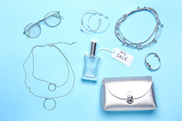 Bottle of perfume for sale with female accessories on color background - Photo, Image