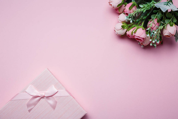 Подарочная коробка и букет цветов на розовом фоне. Вид сверху, плоский. Место для текста
. - Фото, изображение
