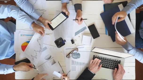 Top view male and female hands of business people planning strategy for corporate project in office. Business team sitting at table and checking financial graphs. Coworkers examining documents at desk - Filmmaterial, Video