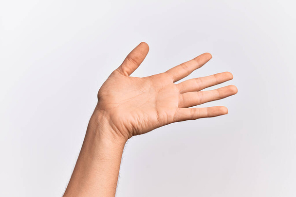 Hand eines kaukasischen jungen Mannes mit Fingern über isoliertem weißem Hintergrund, der sich mit offener Handfläche präsentiert, nach Unterstützung und Hilfe greift, Geste der Unterstützung - Foto, Bild