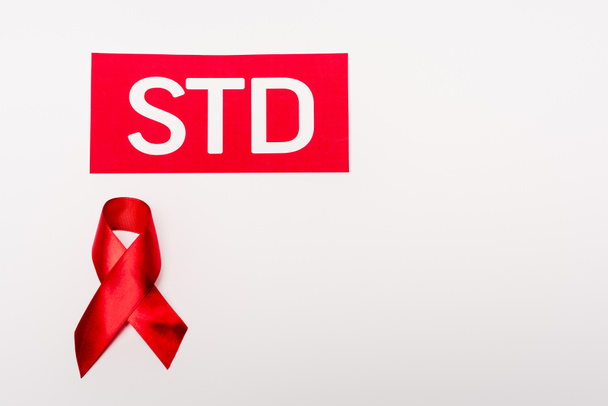 STD harflerinin yanındaki kırmızı kurdelenin üst görüntüsü beyaz üzerine izole edilmiş  - Fotoğraf, Görsel