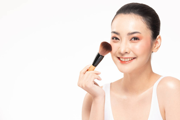 Schönheit asiatische Frau braune Haare suchen Lächeln in der Kamera Glück und halten Make-up Pinsel und fröhlich mit Make-up Pinsel, Beauty-Konzept auf weißem Hintergrund. - Foto, Bild