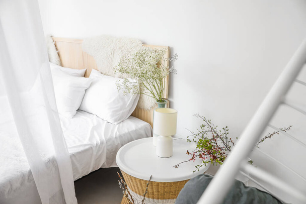 Interior de hermoso dormitorio moderno con flores de primavera - Foto, Imagen