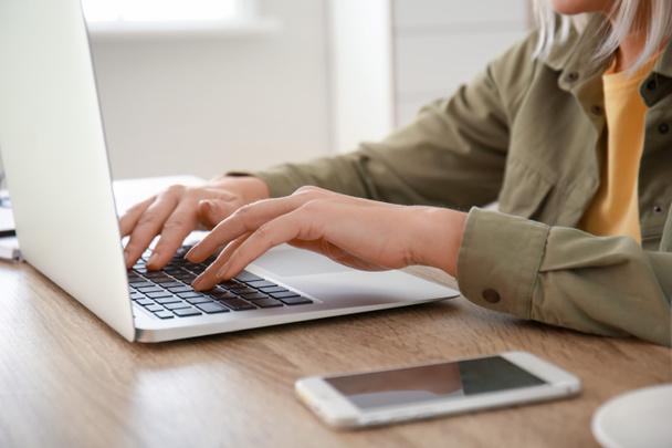Mujer madura usando el ordenador portátil para el aprendizaje en línea en casa, primer plano
 - Foto, imagen