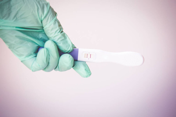 Positieve zwangerschapstest bij een coronaviruspandemie  - Foto, afbeelding