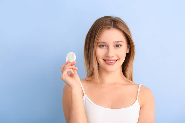 Beautiful young woman with cotton pad on color background - Φωτογραφία, εικόνα
