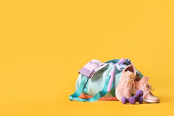 Bolsa con ropa deportiva y equipo sobre fondo de color
 - Foto, Imagen