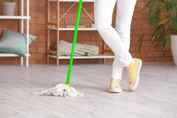 Young woman mopping floor in room - Photo, Image