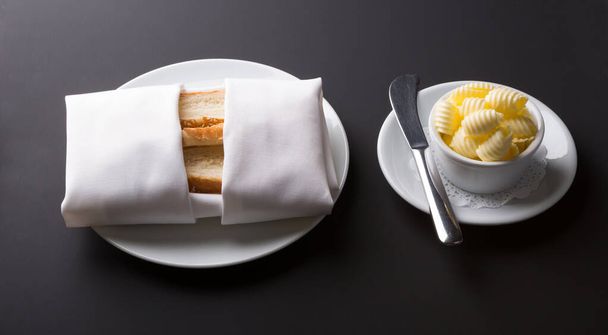 Bread toasts served with butter on a black background - Fotó, kép