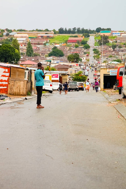 Johannesburg, South Africa - January 17, 2011: African people walking down a main road in Alexandra township, a formal and informal settlement  - Фото, изображение