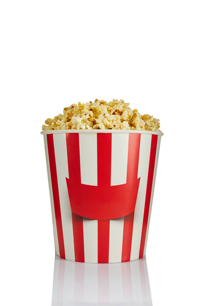 delicious fresh popcorn in paper striped bucket - Foto, Imagen