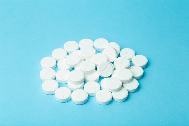 Pills background. Pills, drags and medecine concept. White tablets on a blue background - Foto, imagen