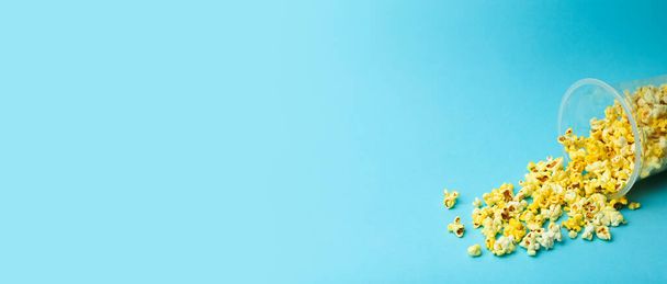Popcorn on a colored banner background. Minimal food concept. Entertainment, film and video content. Aesthetics 80s and 90s concept - Foto, Bild