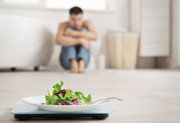 Escalas com salada em prato no banheiro. Conceito de anorexia
 - Foto, Imagem