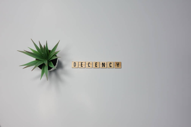 The word Decency written in wooden letter tiles on a white background.  Concept honesty, morality, and character. - Photo, Image