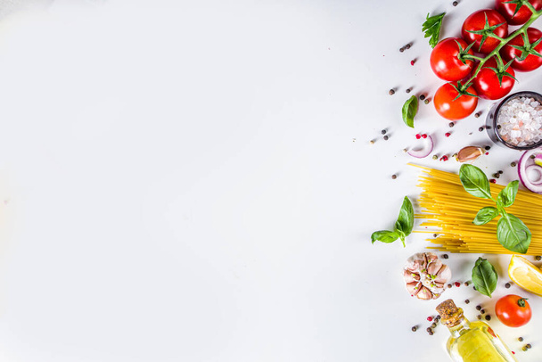 Італійські харчові інгредієнти для приготування Спагетті Паста. Шпагетті-паста з різними інгредієнтами - цибулею, помідорами, часником, базилікою, петрушкою, сиром, оливковою олією. На білому тлі, плоскі копіювання простору - Фото, зображення