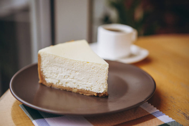 Piece of cake with coffee for breakfast on the table in a coffee shop - Foto, imagen