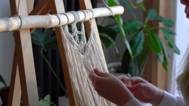 Zůstaň doma. práce během karantény - dívka v obývacím pokoji nástěnné tkaní lan v makrame technice - Záběry, video