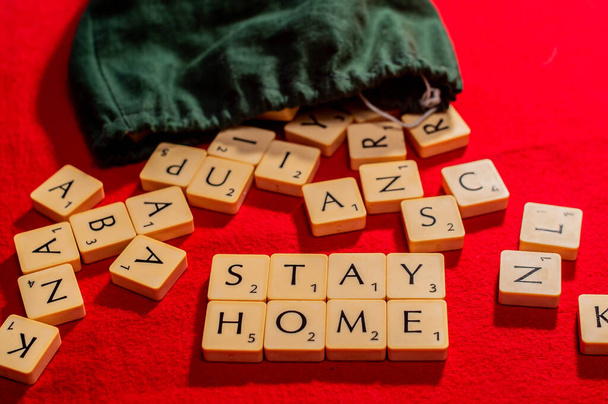 Оставайтесь дома с скраббл плитки, семейная настольная игра. Буквы в мешке, Ковид-19
 - Фото, изображение