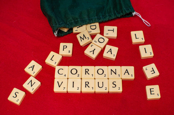 Corona-Virus mit Scrabble-Fliesen, Familienbrettspiel, Leben und Pläne, Briefe im Sack, Covid-19 - Foto, Bild