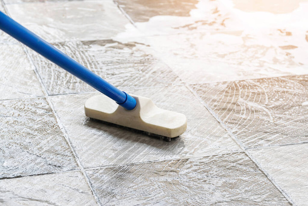 Cleaning the tile floor with floor scrubber brush and water. - Fotó, kép