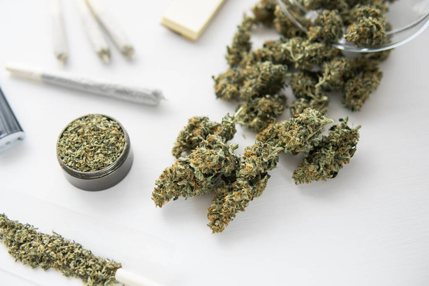 porro con marihuana, molinillo con hierba fresca, brotes de cannabis en la mesa negra, de cerca
, - Foto, Imagen