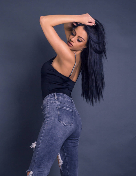 attractive brunette woman posing to camera in grunge jeans - Zdjęcie, obraz