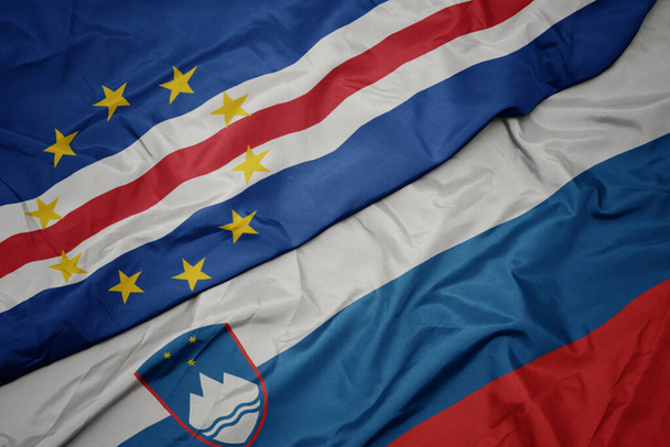 махаючи барвистим прапором Словенії та національним прапором мису Верде. макрос
 - Фото, зображення