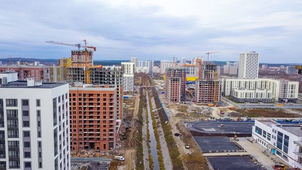 Ekaterinburg, Russia. Flight between buildings under construction over the river. New Construction Area - Akademicheskiy (Academic), Aerial View   - Photo, Image