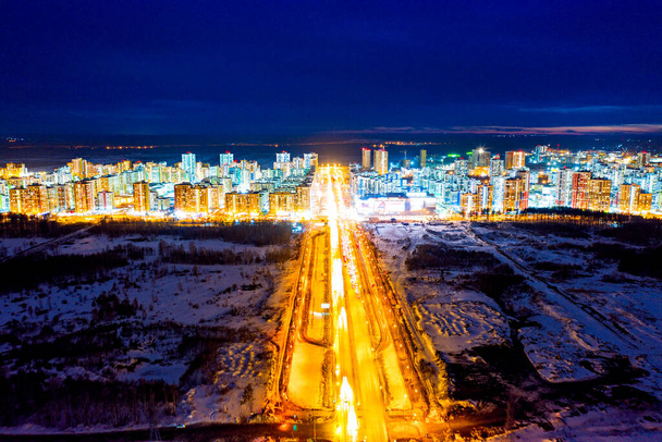 Ekaterinburg, Russia. Un'ampia autostrada illuminata da lanterne con passerelle pedonali. Zona residenziale con nuovi edifici. Vista notturna sulla città - Foto, immagini